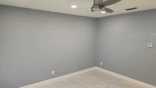an empty room with a ceiling fan and window