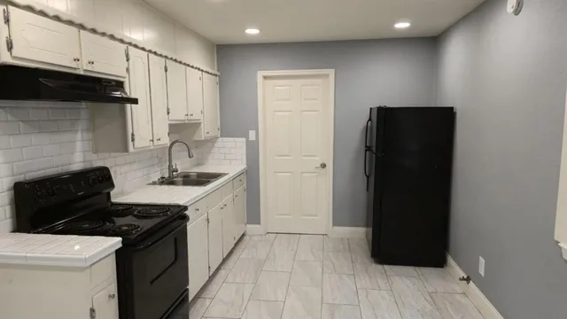 a kitchen with a sink and a stove top oven