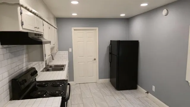 a kitchen with a sink and a refrigerator