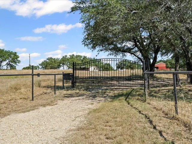 a view of a yard with wooden fence