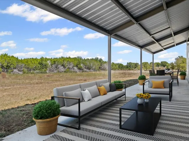 a roof deck with couches and potted plants