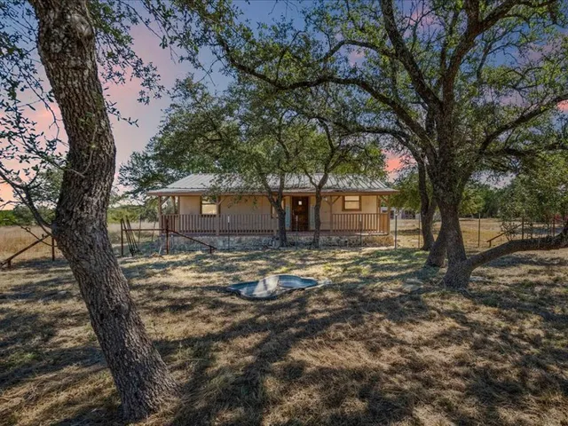 a view of a house with yard tree and wooden fence