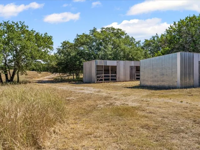 a view of a house with backyard and trees