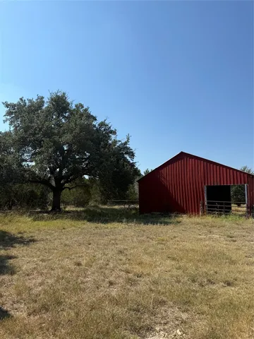 a view of a house with a yard and wooden fence