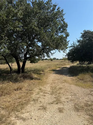 a view of a field with an ocean in the background
