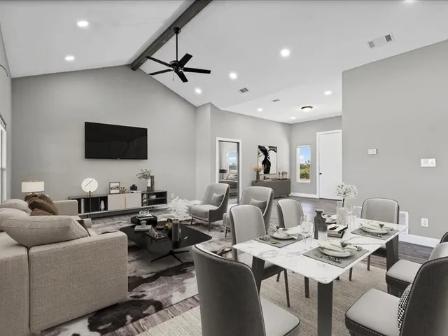 a living room with lots of furniture and view of kitchen