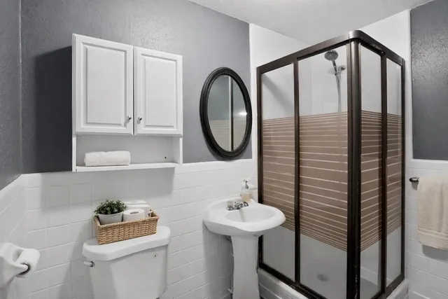 a bathroom with a sink a toilet and a mirror