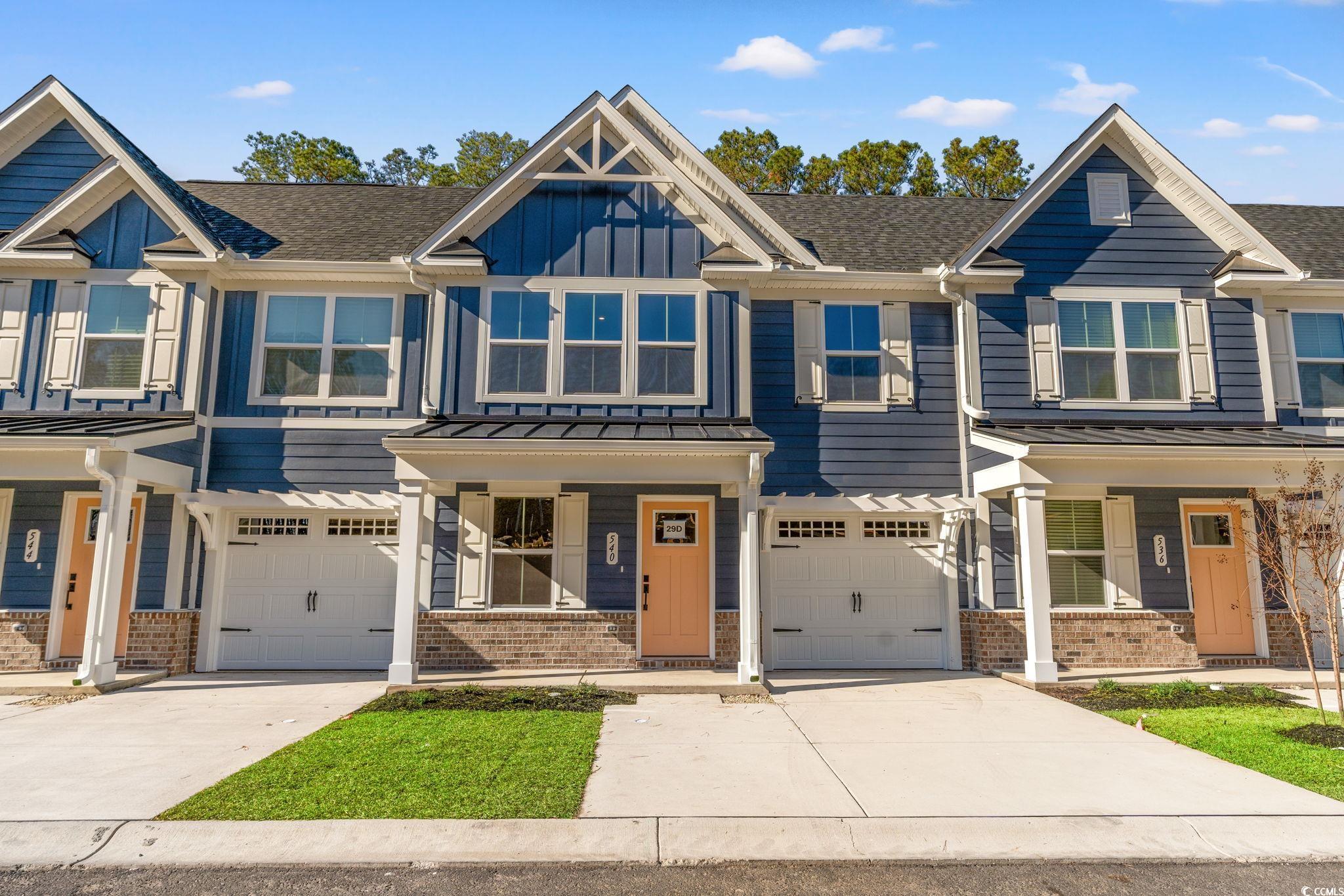 Craftsman inspired home featuring brick siding, covered porch, driveway, and an attached garage