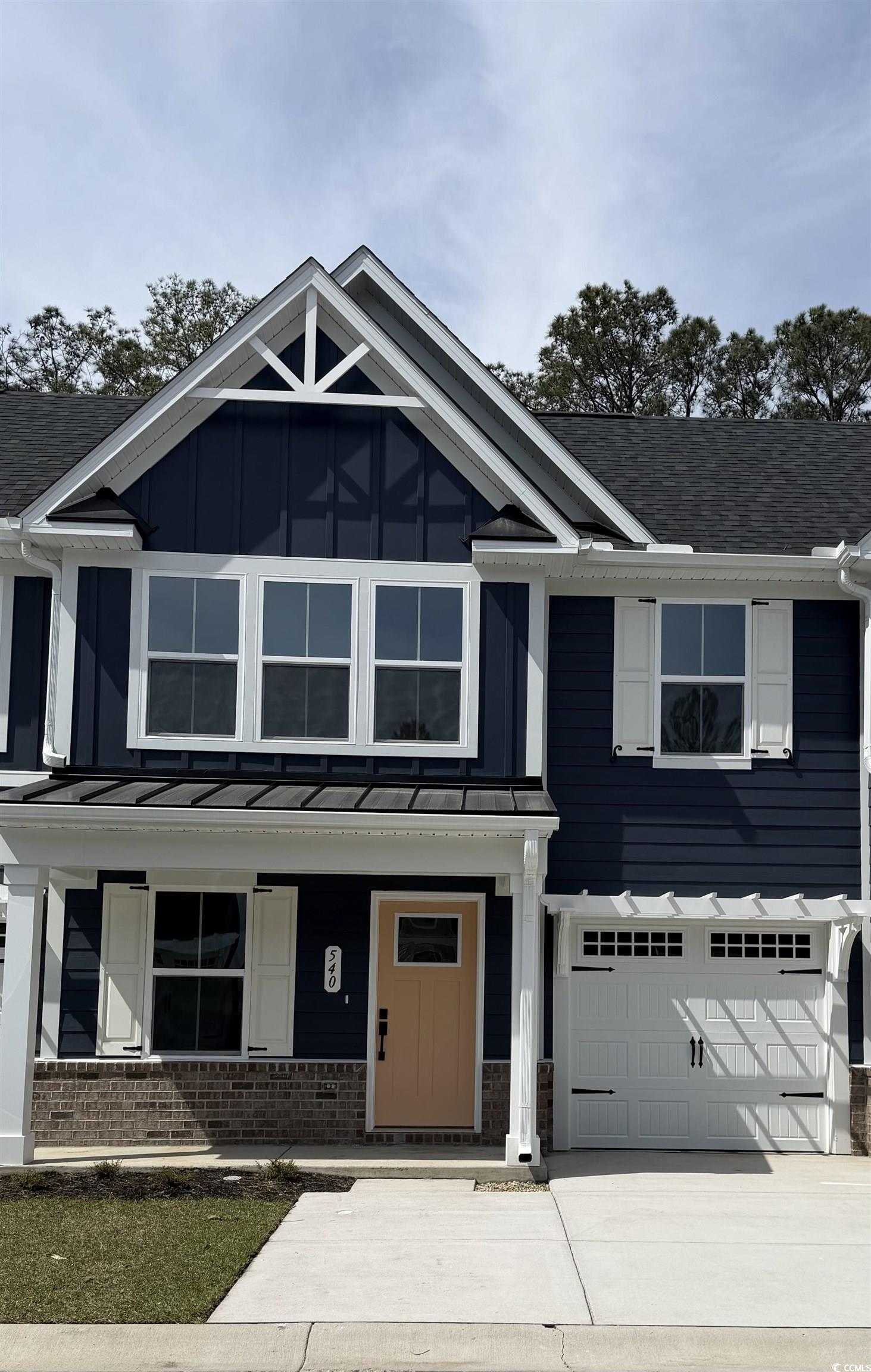 Craftsman inspired home featuring brick siding, covered porch, driveway, and an attached garage