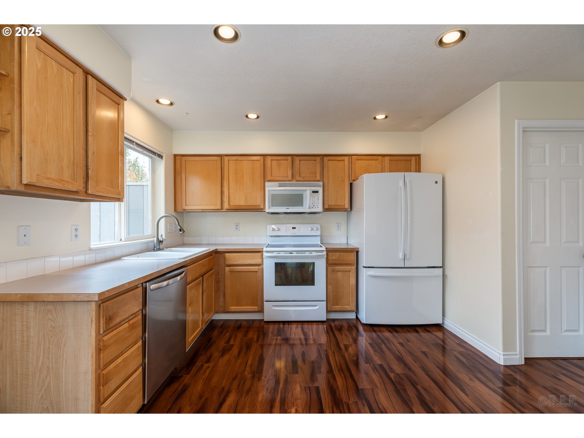 6621 North Columbia Way, Unit 4 Portland, OR 97203 - Photo 6 of 22 a kitchen with kitchen island granite countertop wooden floors stainless steel appliances and sink