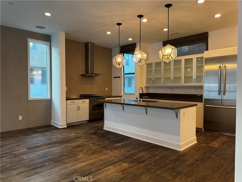 2205 Tom Mix Road Los Angeles, CA 90026 - Photo 1 of 20 a large kitchen with stainless steel appliances kitchen island a large counter top a sink and a wooden floor