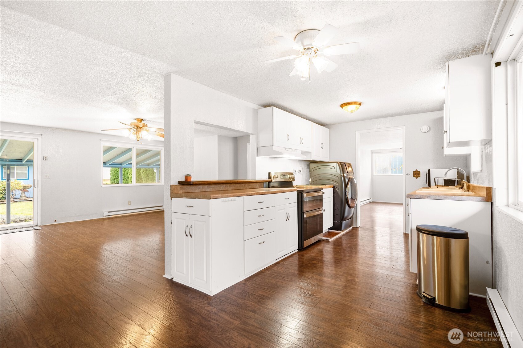 504 South 6th Street McCleary, WA 98557 - Photo 5 of 40 a kitchen with wooden floors and white appliances