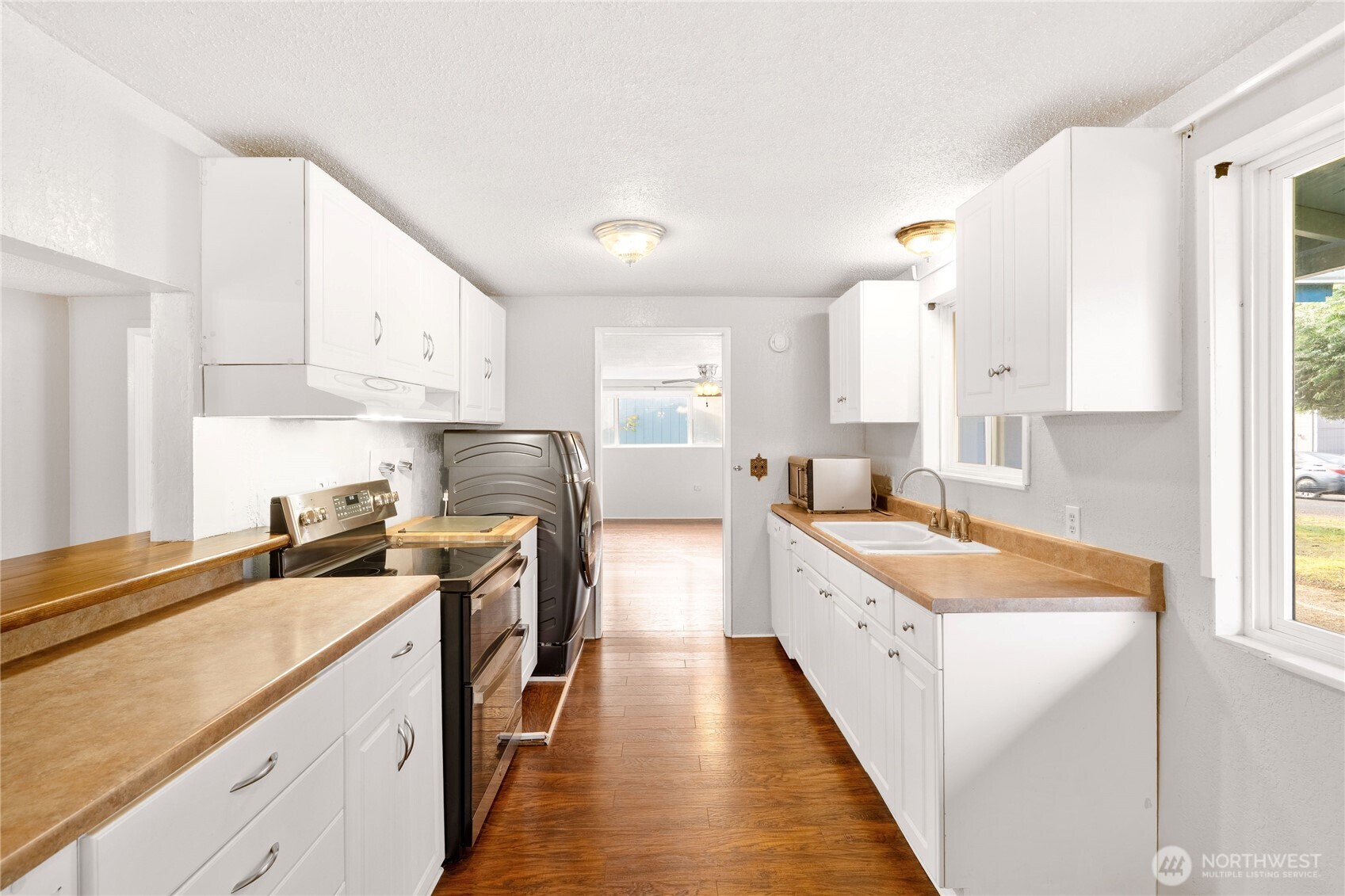 504 South 6th Street McCleary, WA 98557 - Photo 6 of 40 a kitchen with a sink stove top oven and cabinets