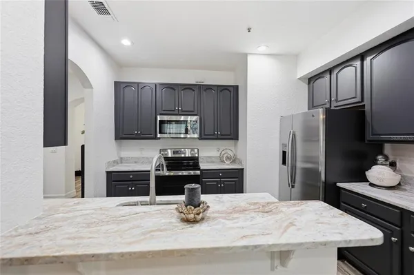 a kitchen with stainless steel appliances granite countertop a sink stove and refrigerator