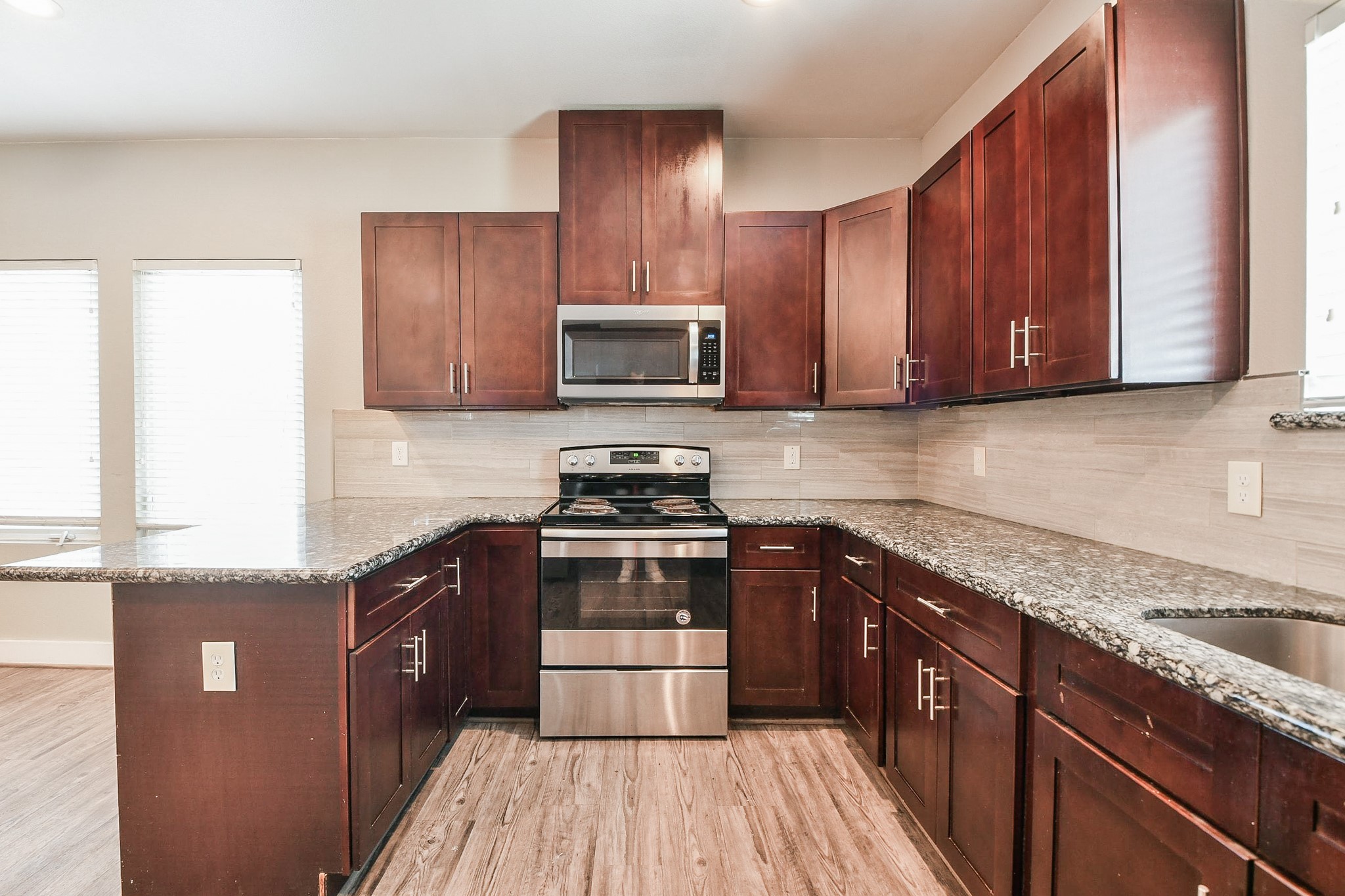 3249 Dixie Drive, Unit B Houston, TX 77021 - Photo 5 of 25 a kitchen with granite countertop wooden cabinets and stainless steel appliances
