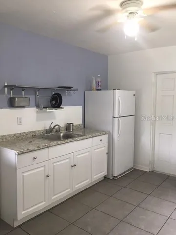 a kitchen with granite countertop cabinets and refrigerator