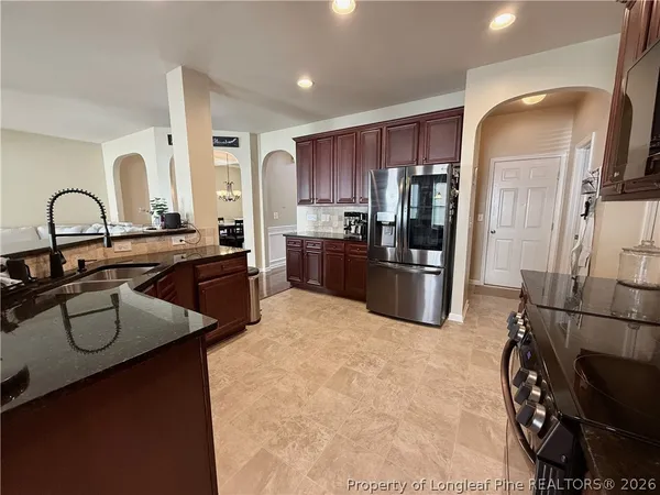 a kitchen with stainless steel appliances granite countertop a refrigerator sink and cabinets