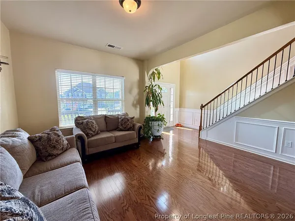 a living room with furniture and a wooden floor