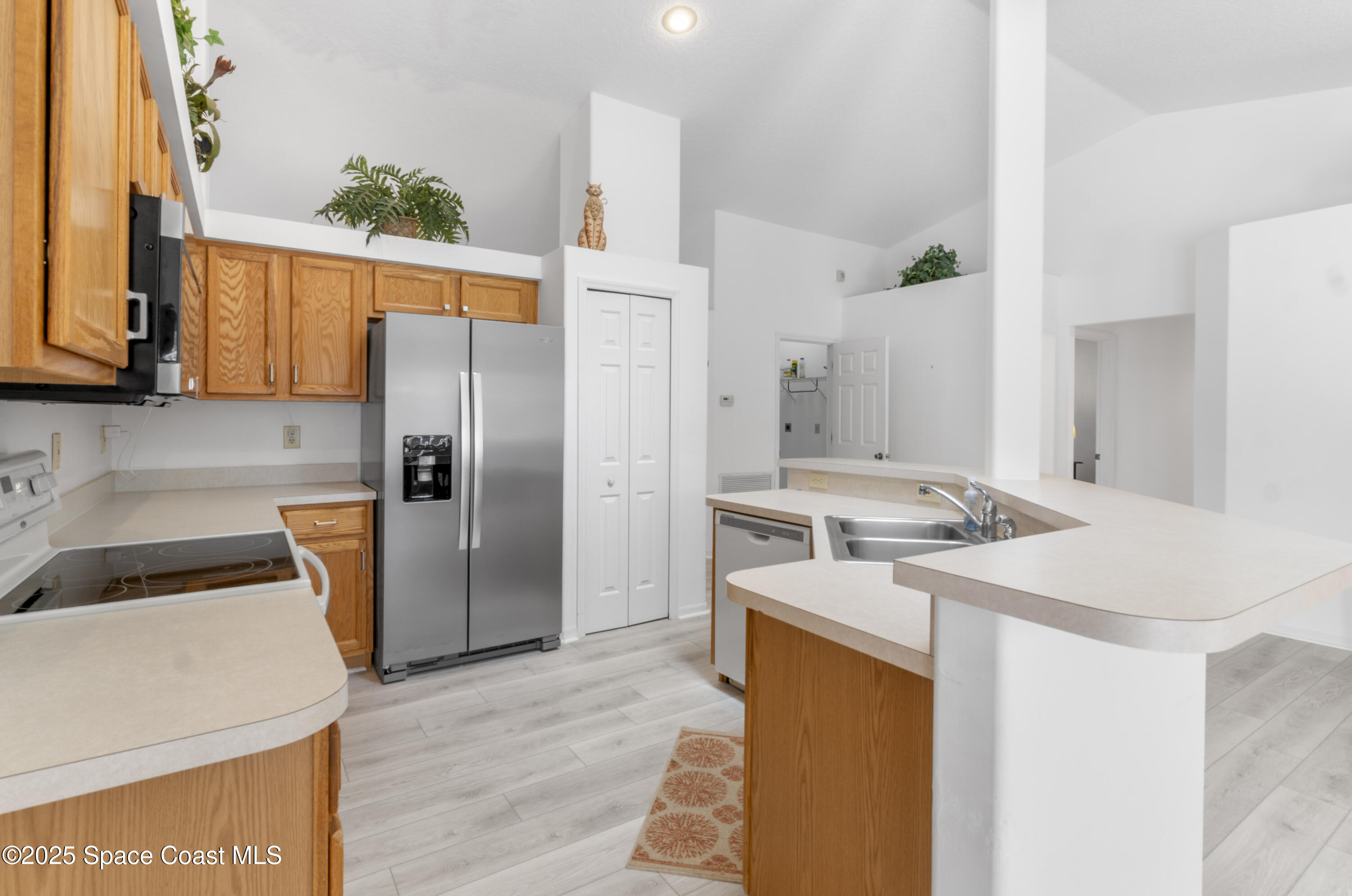 5155 3rd Manor Vero Beach, FL 32968 - Photo 9 of 29 a kitchen with stainless steel appliances granite countertop a refrigerator a stove and a sink with wooden floor