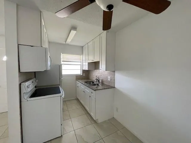 a kitchen with granite countertop a sink and a stove top oven
