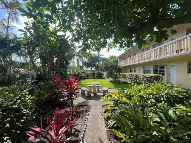 a view of a house with a big yard and large trees
