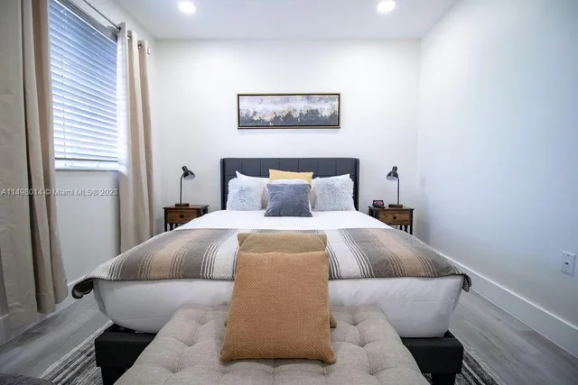 a bedroom with a bed and a painting on the wall