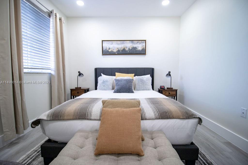 18706 Southwest 100th Avenue, Unit 18706 Cutler Bay, FL 33157 - Photo 13 of 20 a bedroom with a bed and a painting on the wall