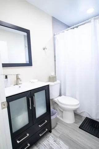 a bathroom with a toilet sink and mirror