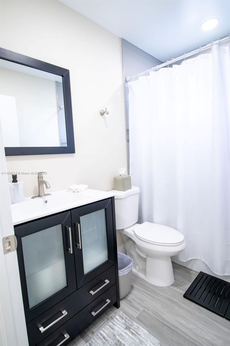 18706 Southwest 100th Avenue, Unit 18706 Cutler Bay, FL 33157 - Photo 18 of 20 a bathroom with a toilet sink and mirror