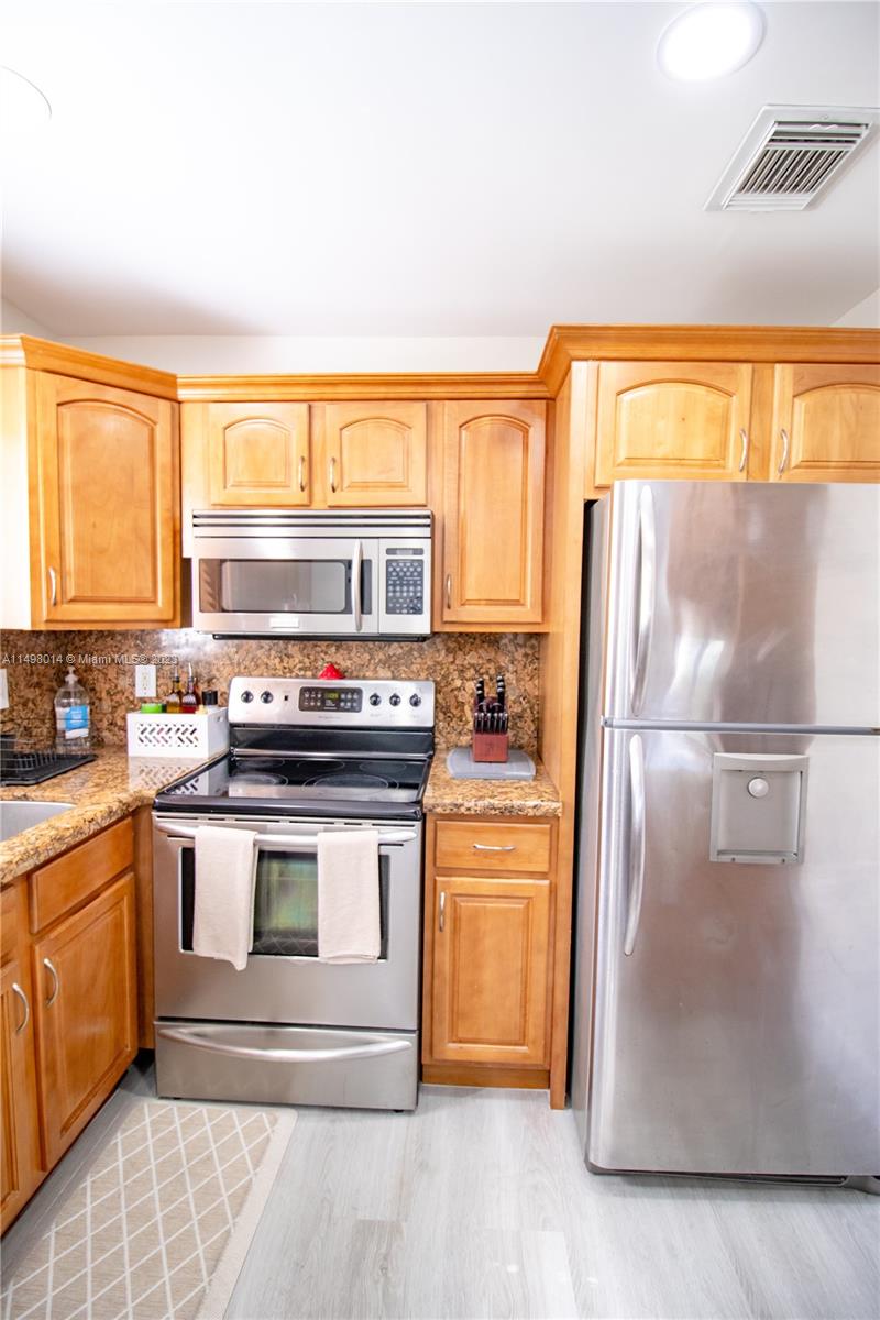 18706 Southwest 100th Avenue, Unit 18706 Cutler Bay, FL 33157 - Photo 9 of 20 a kitchen with stainless steel appliances granite countertop a stove a refrigerator and a microwave