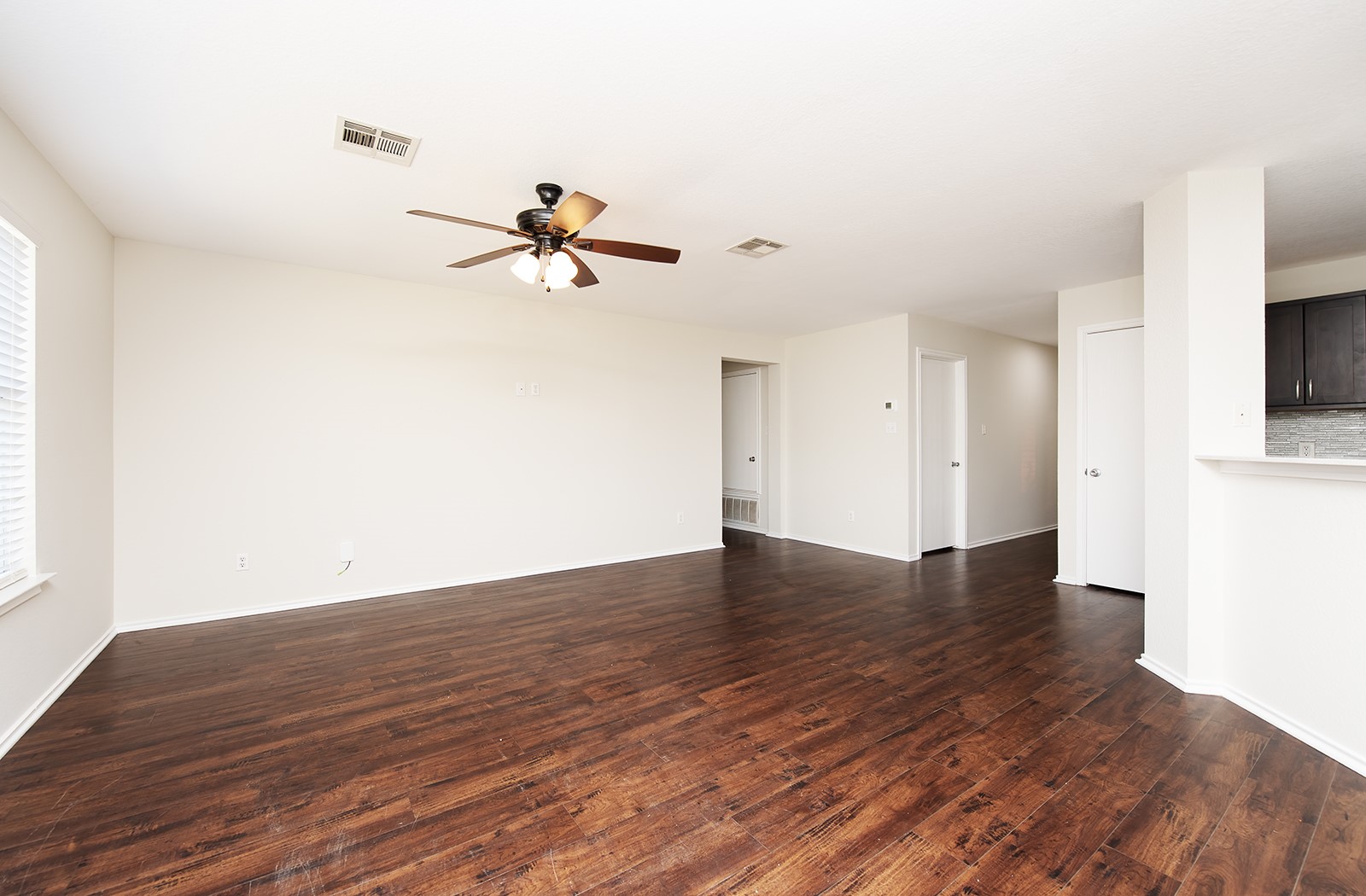 1004 Bluff Meadow Cove Georgetown, TX 78626 - Photo 13 of 26 a view of a room with wooden floor and a ceiling fan