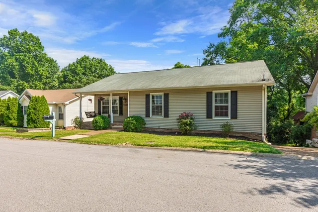 a front view of a house with a yard and trees