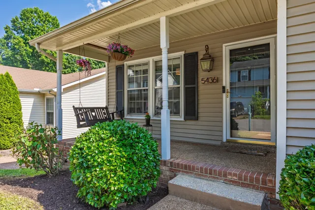 a yellow house with flower garden in front of it