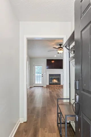 a view of an empty room with window and wooden floor