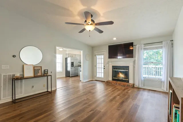 an empty room with wooden floor and a ceiling fan