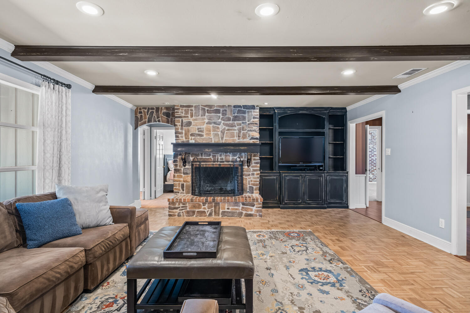 3206 56th Street Lubbock, TX 79413 - Photo 5 of 32 a living room with furniture a flat screen tv and a fireplace
