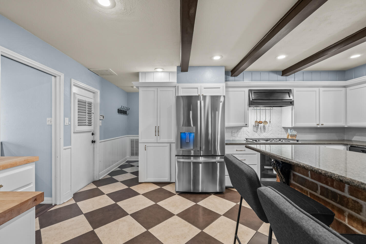 3206 56th Street Lubbock, TX 79413 - Photo 8 of 32 a kitchen with stainless steel appliances kitchen island granite countertop a refrigerator and a sink