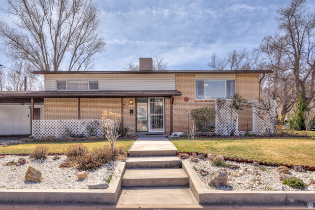 738 Locust Lane Moab, UT 84532 - Photo 2 of 25 Tri-level home featuring a front yard, brick siding, and a chimney