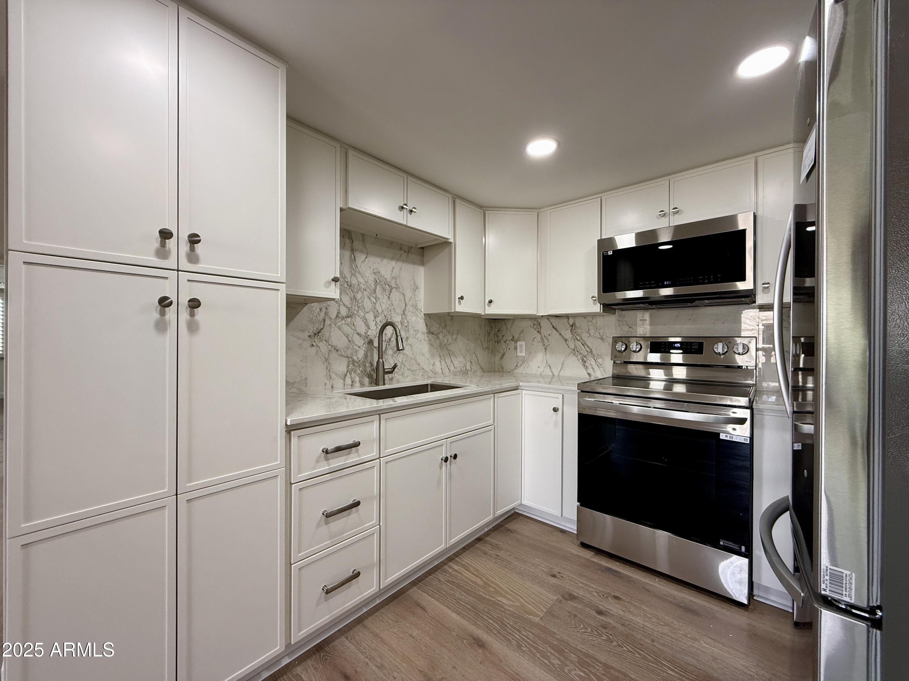 7930 East Camelback Road, Unit 709 Scottsdale, AZ 85251 - Photo 11 of 41 a kitchen with stainless steel appliances white cabinets and a sink