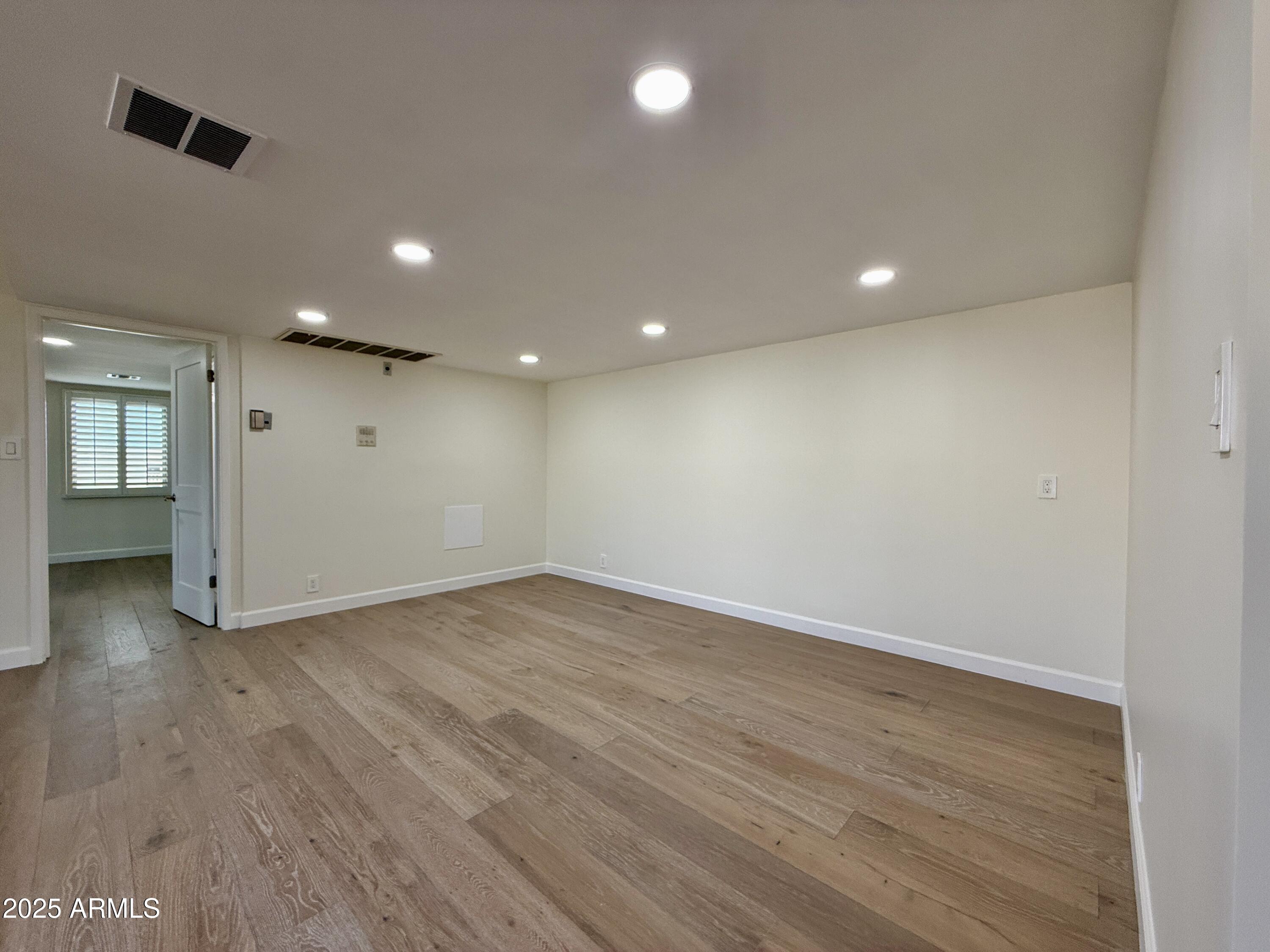 7930 East Camelback Road, Unit 709 Scottsdale, AZ 85251 - Photo 14 of 41 an empty room with wooden floor and windows