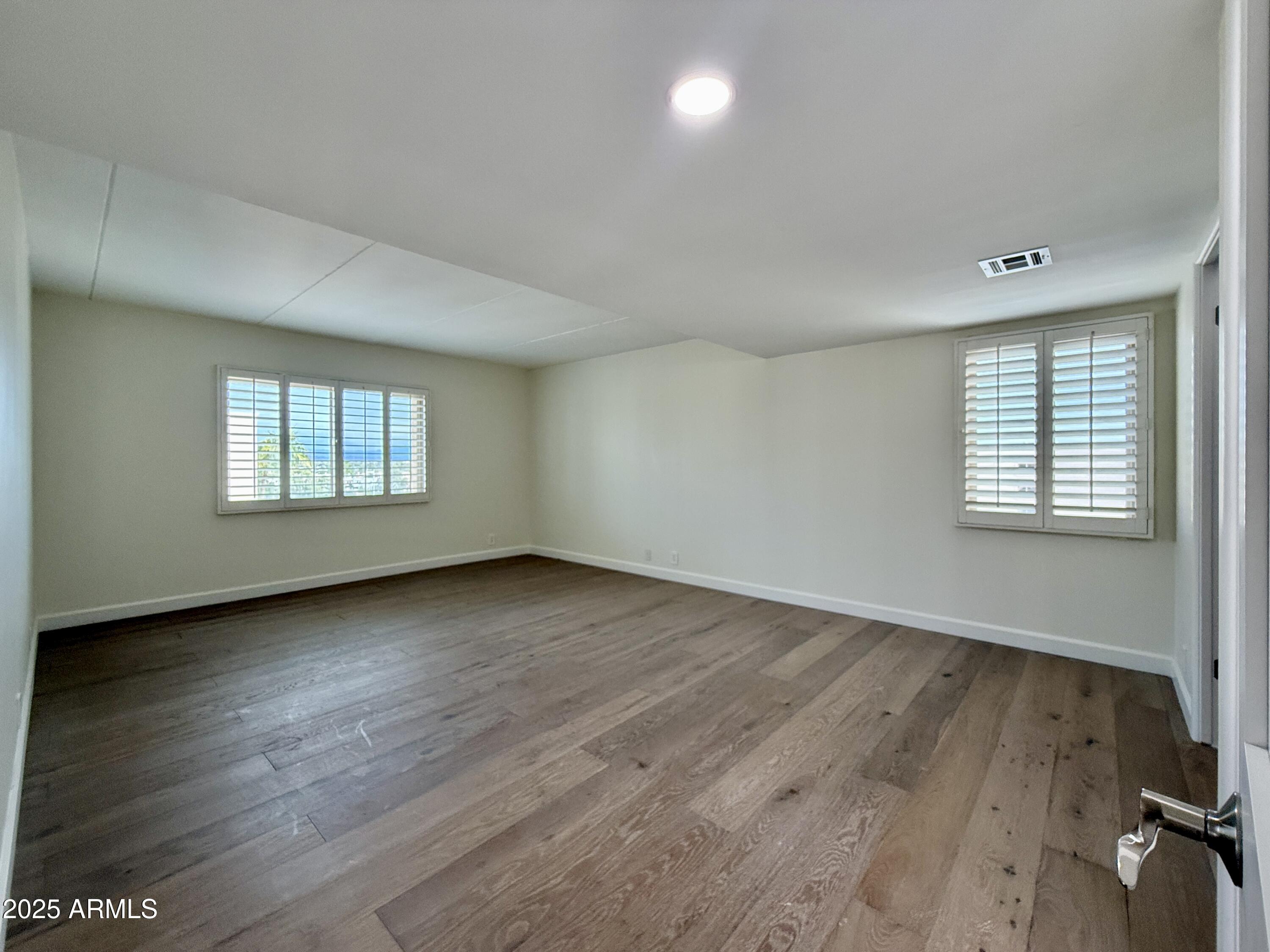 7930 East Camelback Road, Unit 709 Scottsdale, AZ 85251 - Photo 20 of 41 an empty room with wooden floor and windows