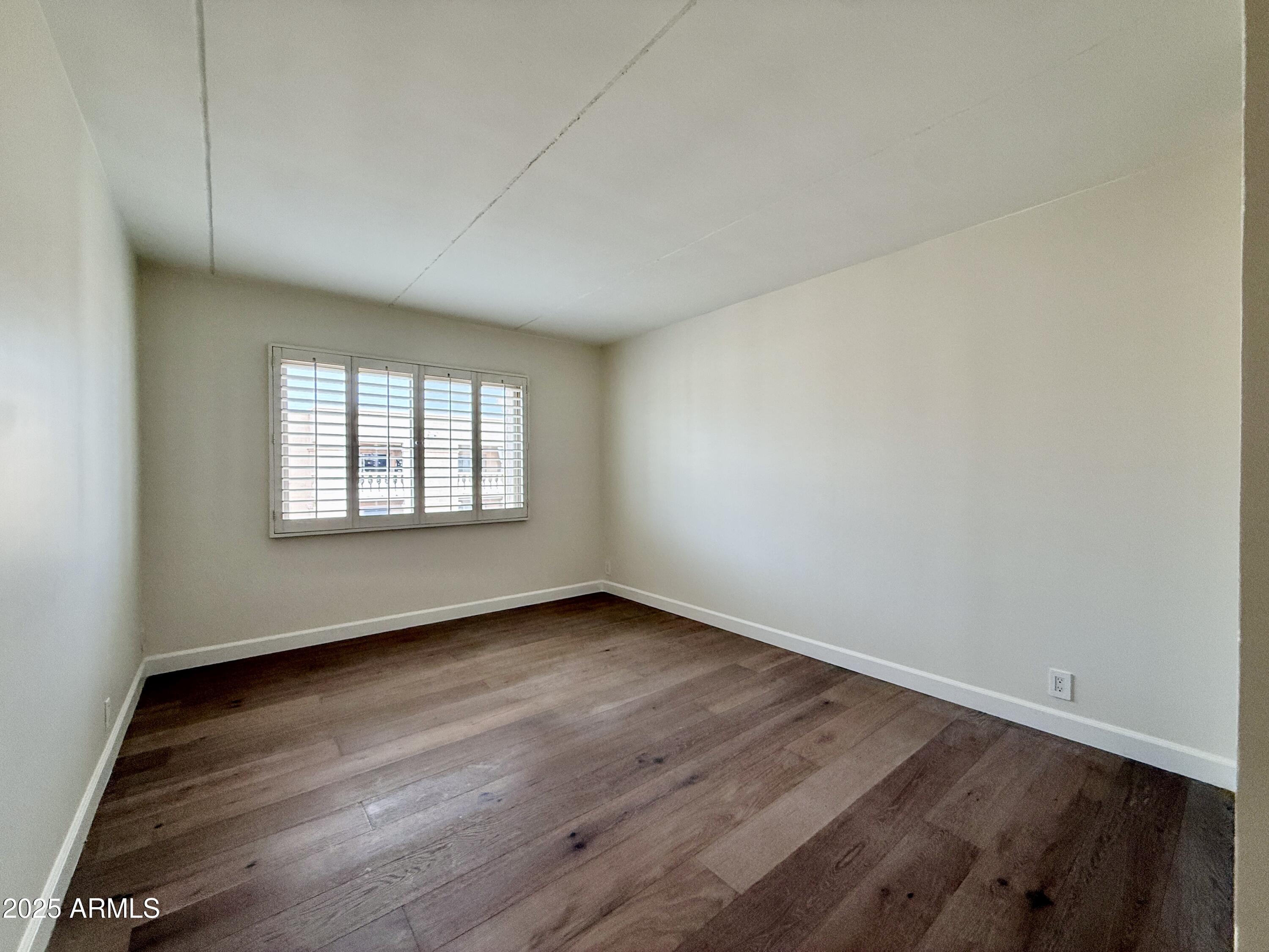 7930 East Camelback Road, Unit 709 Scottsdale, AZ 85251 - Photo 25 of 41 an empty room with wooden floor and windows