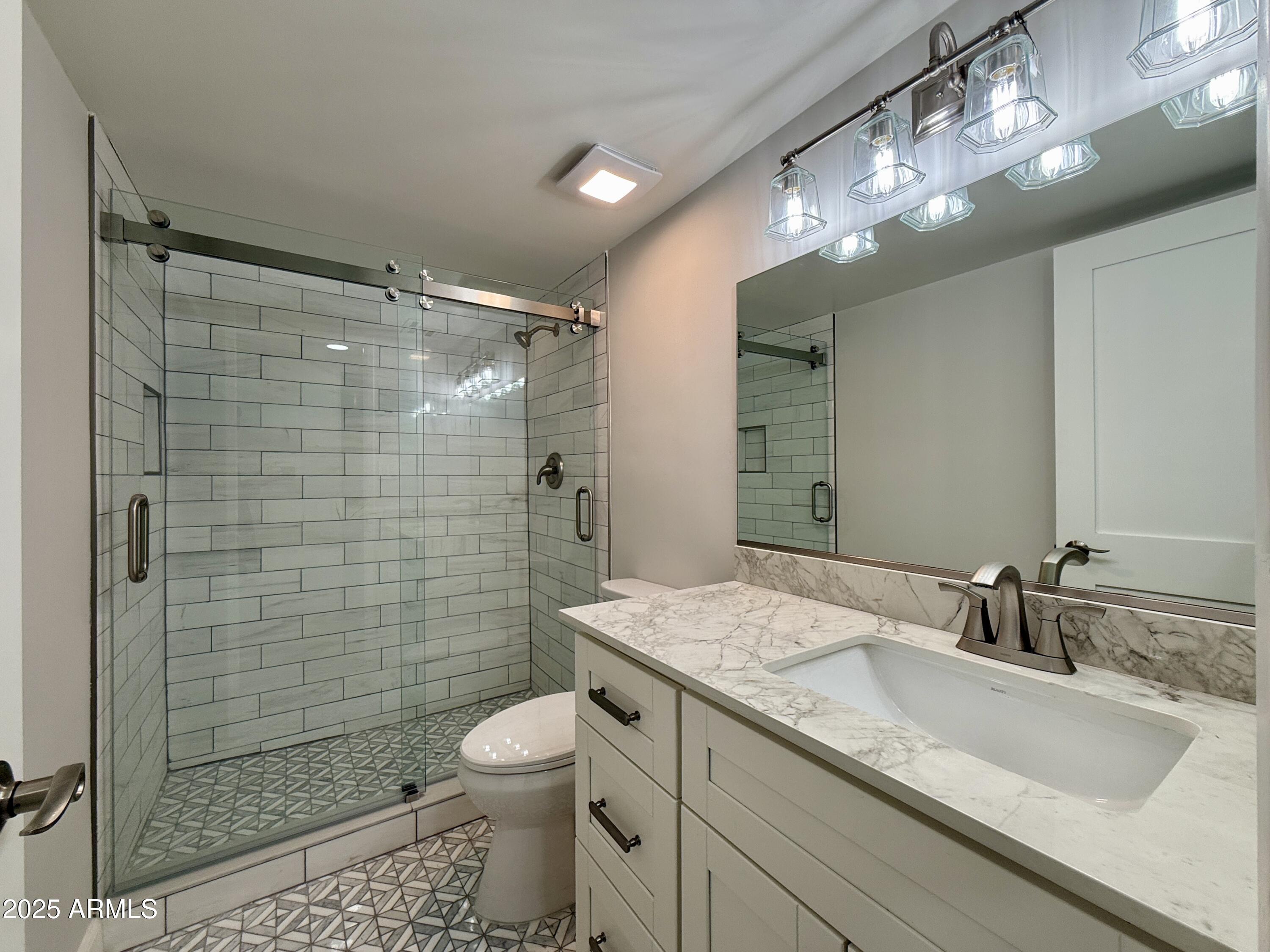 7930 East Camelback Road, Unit 709 Scottsdale, AZ 85251 - Photo 27 of 41 a bathroom with a granite countertop sink mirror toilet and shower