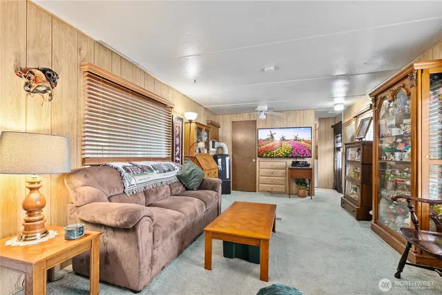 a living room with furniture a flat screen tv and a window