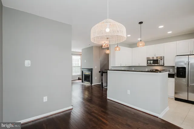 a kitchen with granite countertop white cabinets and black appliances