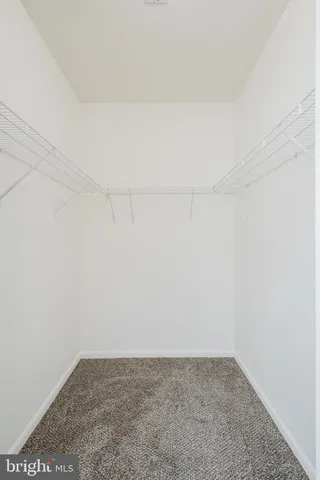 a large white building with a large parking space and a street view