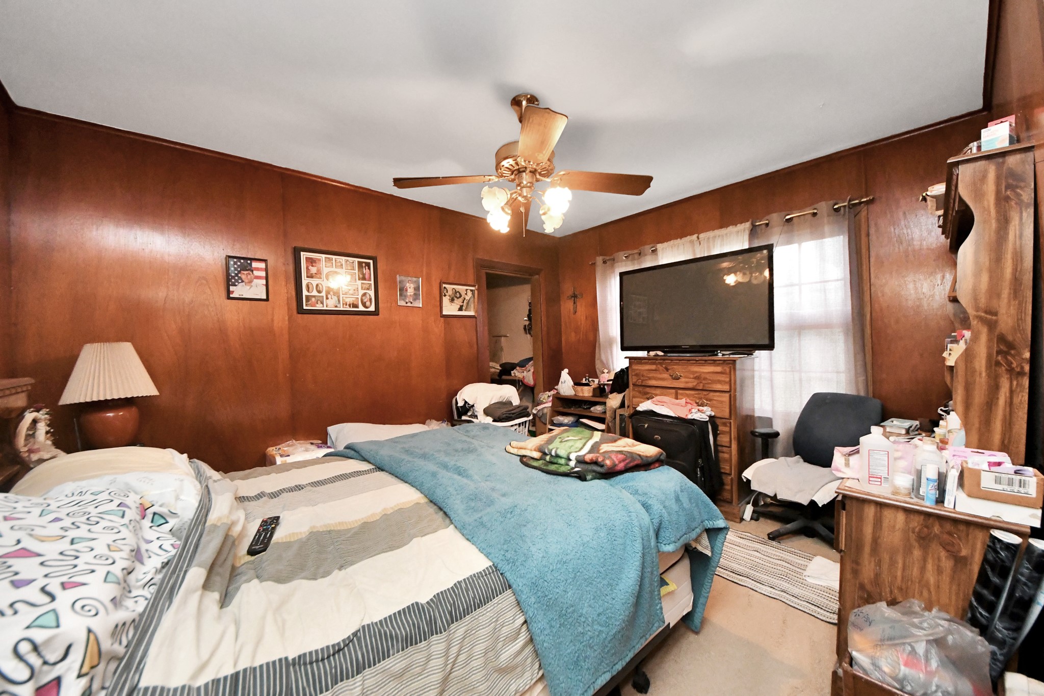 5134 Leeland Street Houston, TX 77023 - Photo 16 of 28 a bedroom with bed a flat tv screen and a lamp on the dresser