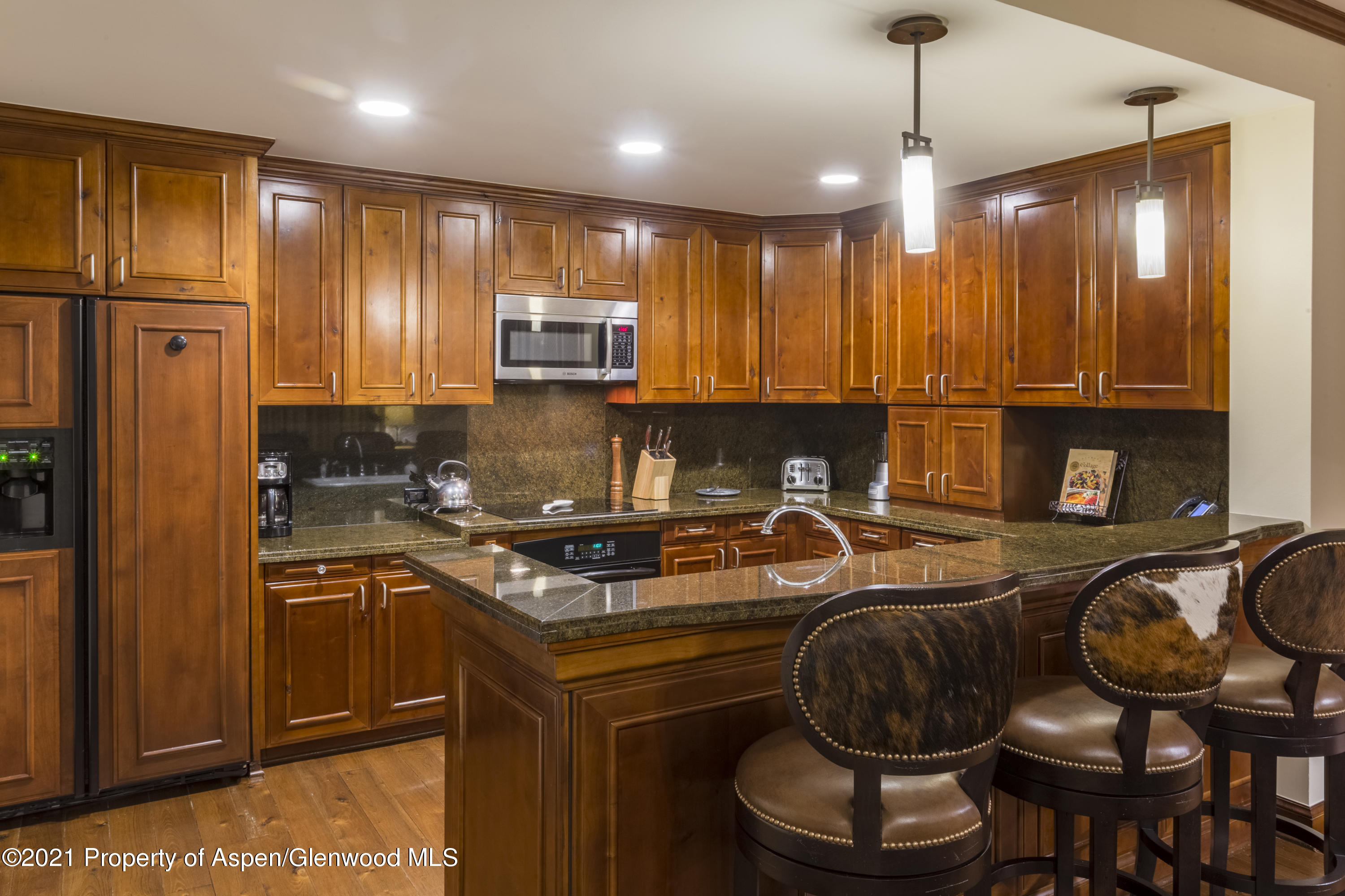 197 Prospector Road, Unit 2412 SUMMER INTEREST #10 Aspen, CO 81611 - Photo 9 of 22 a kitchen with stainless steel appliances granite countertop a stove a sink and a refrigerator