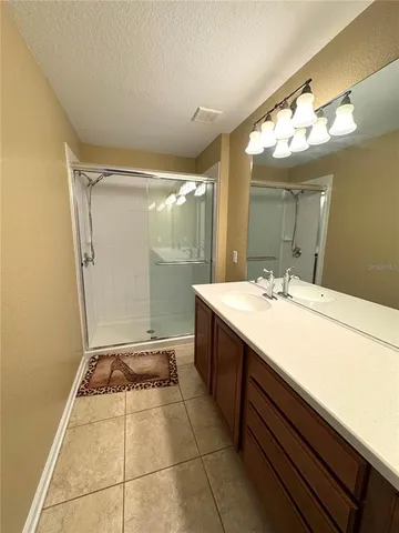 a bathroom with a sink mirror and a shower
