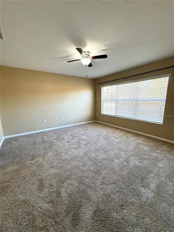 7752 Moser Avenue Windermere, FL 34786 - Photo 17 of 22 an empty room with chandelier fan and windows